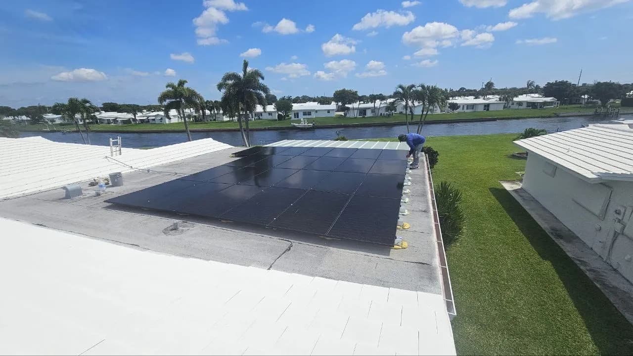 Sprightful Solar 9.75 kW canal-facing rooftop array at the Boynton Beach residence in Boynton Beach, Florida, with an installer finishing module attachment